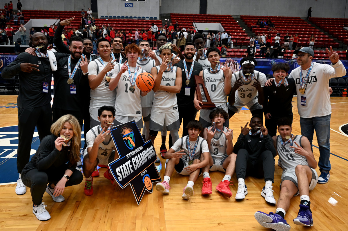Riviera Prep players and coaches gather around the Class 3A state championship trophy after beating Windermere Prep for the second straight season in the state final.